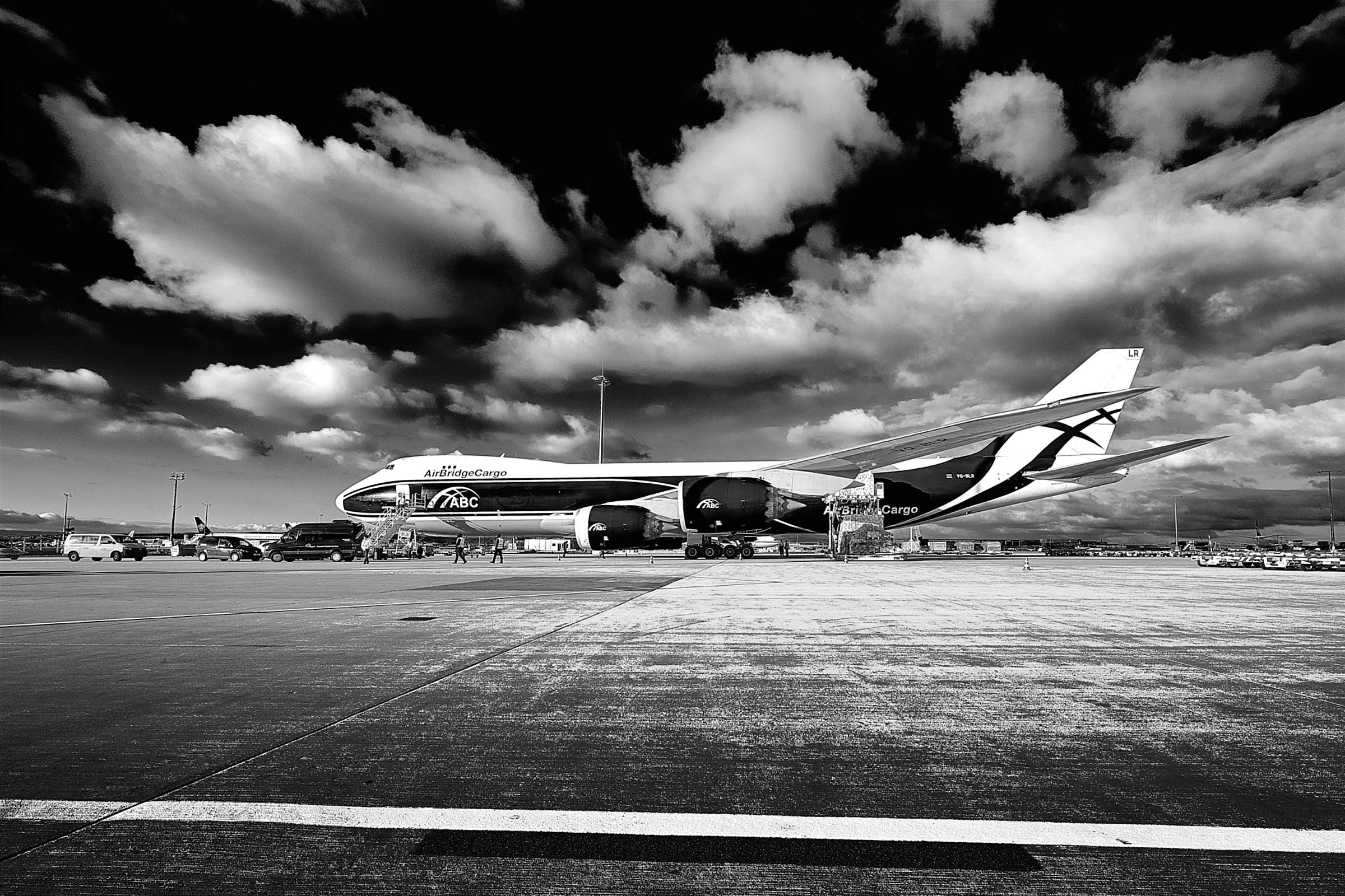 flugzeug-vorfeld-vor-dramatischem-himmel-schwarz-weiß