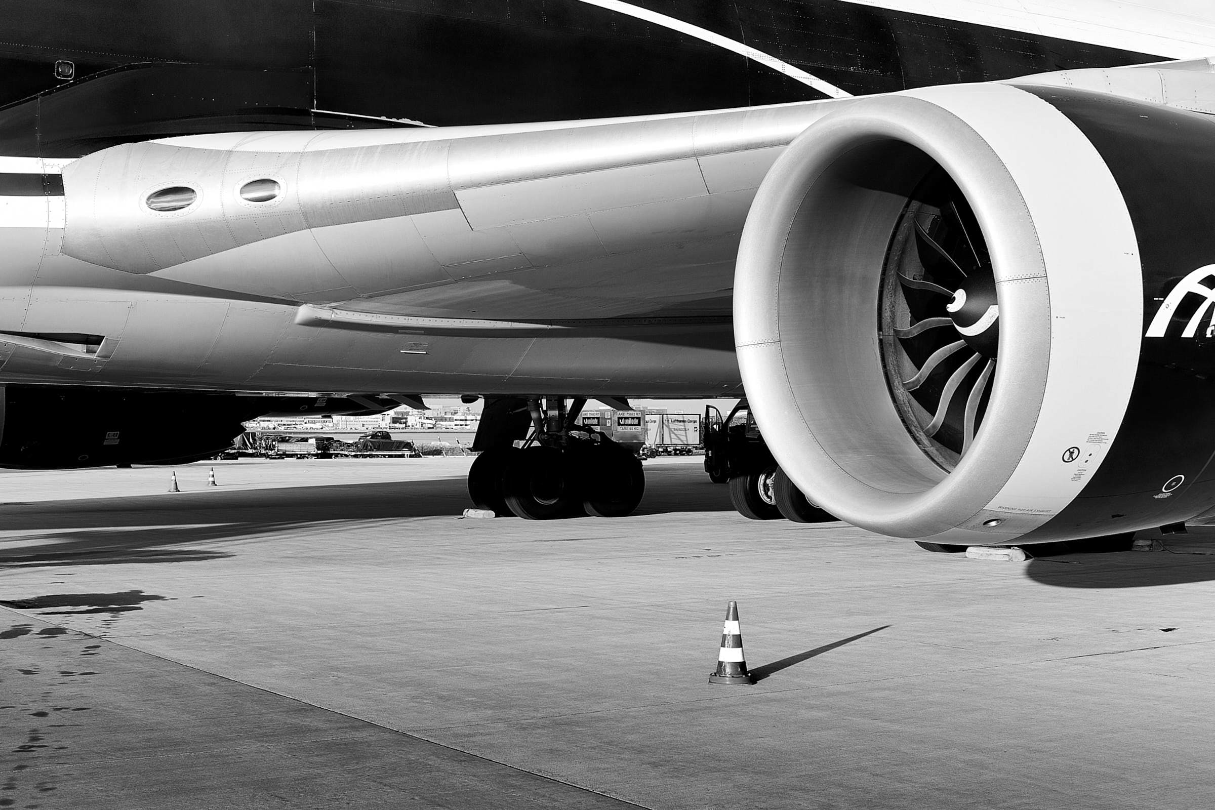 flugzeug-fluegel-mit-turbine-auf-vorfeld-schwarz-weiß
