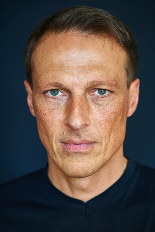 managerportrait-headshot-vor-dunklem-hintergrund